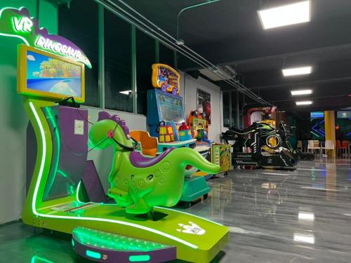 a childrens room with an arcade with an dinosaur game at Hotel Vista Verde in Yauco
