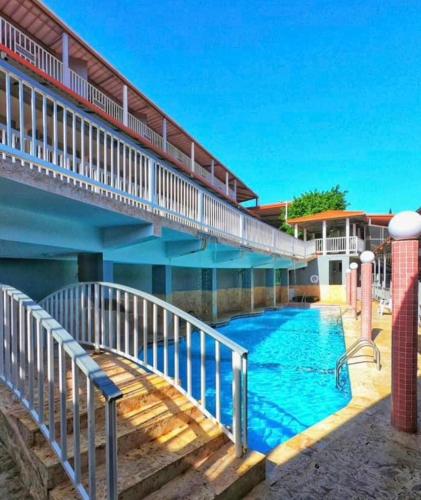 a swimming pool with a stairway leading up to a building at Hotel Vista Verde in Yauco