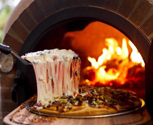 a pizza being inserted into a pizza oven at Hotel Vista Verde in Yauco