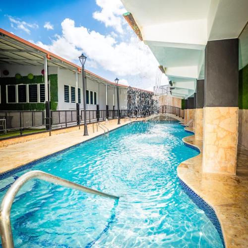 a swimming pool with blue water in a building at Hotel Vista Verde in Yauco