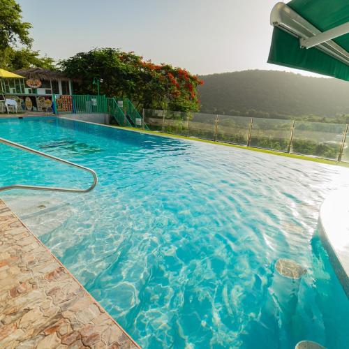 a large blue swimming pool with a mountain in the background at Hotel Vista Verde in Yauco
