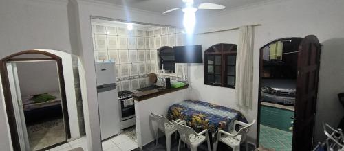 eine Küche mit einer Theke und Stühlen in einem Zimmer in der Unterkunft Casa de Praia Bertioga-Costa do Sol Guaratuba in Bertioga