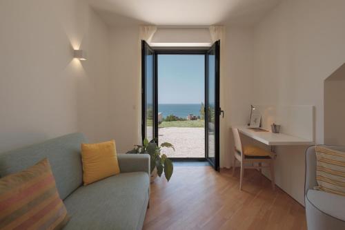 a living room with a couch and a desk at Donna Paolina Rooms & Apartments in Villammare