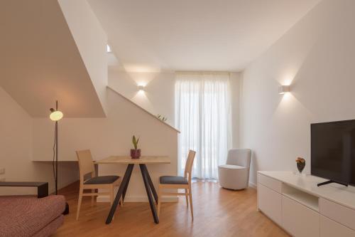 a living room with a dining room table and a television at Donna Paolina Rooms & Apartments in Villammare