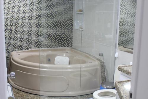 a bathroom with a tub and a toilet at Casa Luxuosa - Porto de Galinhas in Porto De Galinhas