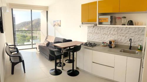 eine Küche mit Theke, Tisch und Couch in der Unterkunft apartamento con vista al mar in Santa Marta
