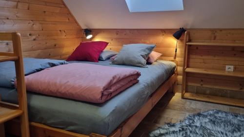 a bedroom with two beds in a wooden room at Domki Na Wzgórzu in Nowica