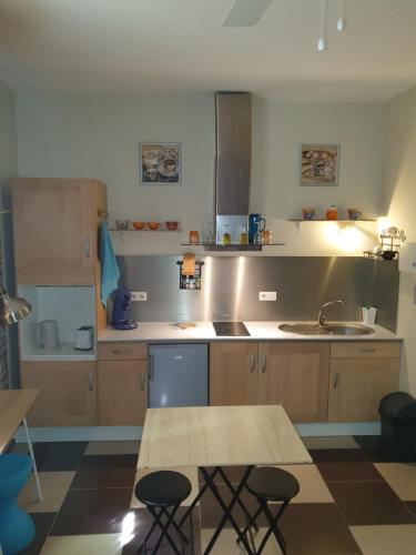 une cuisine avec des armoires en bois, un évier et une table dans l'établissement Studio climatisé intramuros, à Avignon