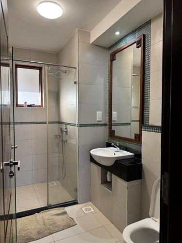 a bathroom with a shower and a sink and a toilet at Sultan Palace Luxury Home in Kikambala