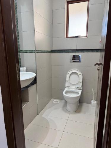 a small bathroom with a toilet and a sink at Sultan Palace Luxury Home in Kikambala