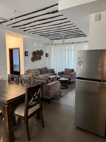 a kitchen and living room with a refrigerator and a table at Sultan Palace Luxury Home in Kikambala