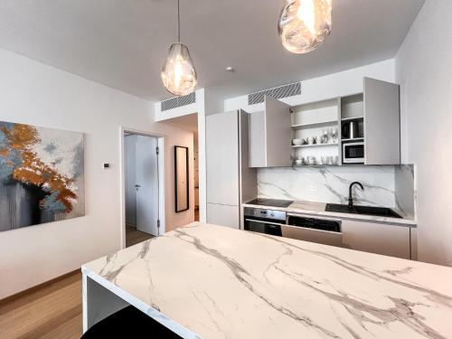a kitchen with white cabinets and a marble counter top at City View Apartment in SKY PARK by Zaha Hadid in Nivy