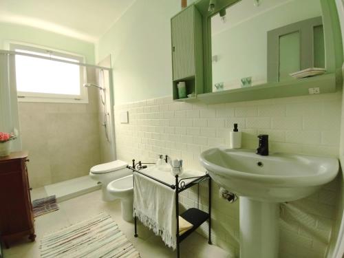 ein weißes Badezimmer mit Waschbecken und Toilette in der Unterkunft Mamma Assuntina in Lecce