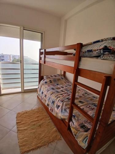 アガディールにあるAppartement Belle Vue Imi Ouaddarのベッドルーム1室(二段ベッド2組付)、バルコニーが備わります。