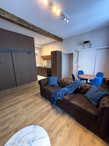 a living room with a brown couch and blue chairs at Blue Note - Le Jazz au cœur de Vienne - Videoprojecteur - Hypercentre in Vienne