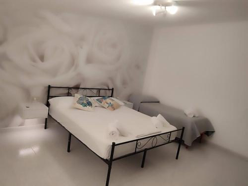 a bedroom with a bed and a white wall at Family & Friends - Room 2 - Second Floor - shared bathroom in Galtellì