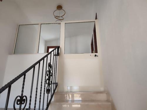 a staircase in a house with a glass wall at Family & Friends - Room 2 - Second Floor - shared bathroom in Galtellì