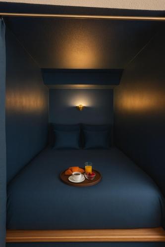 a bed with a tray with a plate of food and a drink at Blue Note - Le Jazz au cœur de Vienne - Videoprojecteur - Hypercentre in Vienne