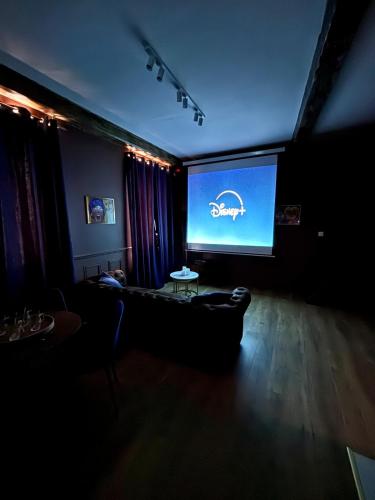 a living room with a couch and a large screen at Blue Note - Le Jazz au cœur de Vienne - Videoprojecteur - Hypercentre in Vienne