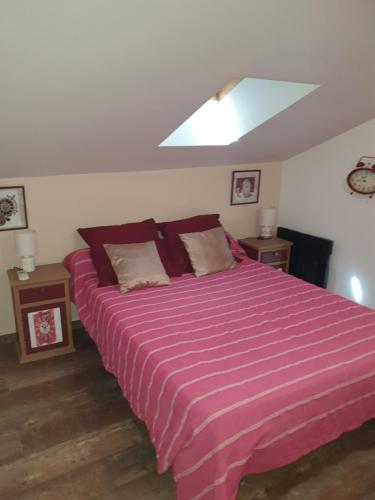 une chambre avec un grand lit avec une couverture à rayures violettes dans l'établissement Appart 2 chambres intramuros climatisé, à Avignon