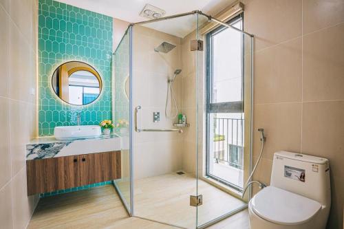 a bathroom with a toilet and a glass shower at Moonlight Villa Vlasta Sam Son in Thanh Hóa