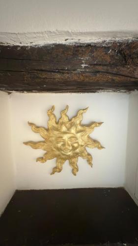 a gold sun decoration on a white wall at Secret Place Central in Udine