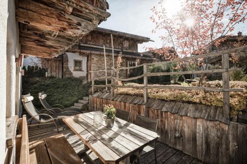 a patio with a table and chairs and a fence at Hüttendorf Ladizium in Ladis