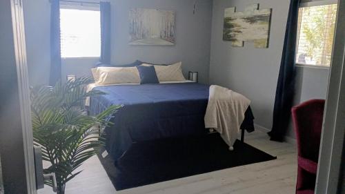 a bedroom with a bed with blue sheets and a plant at Modern Industrial Oasis Private Room with King Bed WiFi FREE Parking and More in Alamogordo