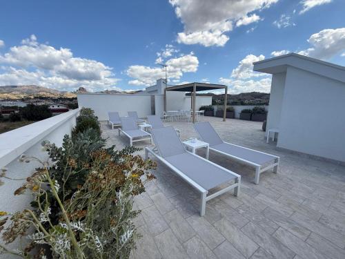 a group of white lounge chairs on a roof at SunBeach 44 - Skyview B&B in Melito di Porto Salvo