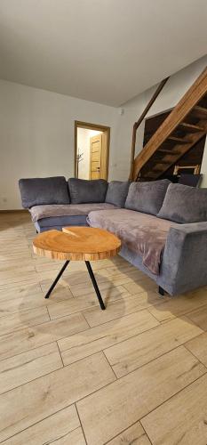 a living room with a couch and a coffee table at Leśna Przystań Bory Tucholskie in Łuby