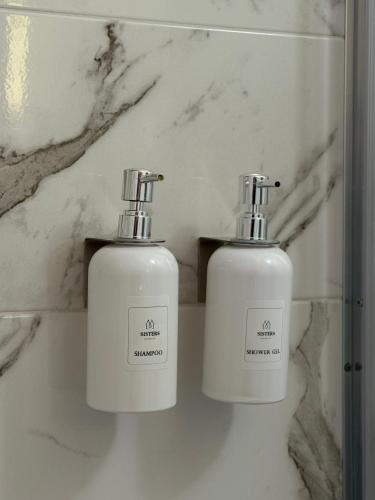 two white bottles ofodorizers sitting on a counter at Sisters residence in Kotor