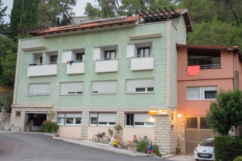 a green building with white windows and a street at Pansion 8 ferala in Novigrad Dalmatia