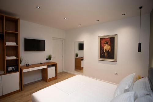 a living room with a bed and a television at Villa Klaus Center Hotel in Tirana
