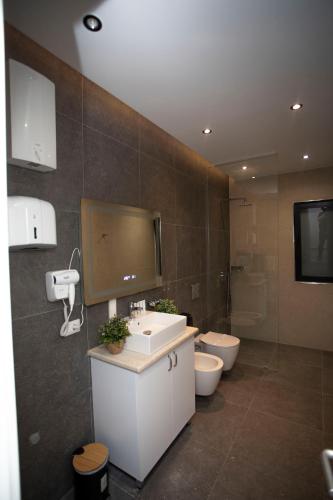a bathroom with a sink and two toilets at Villa Klaus Center Hotel in Tirana