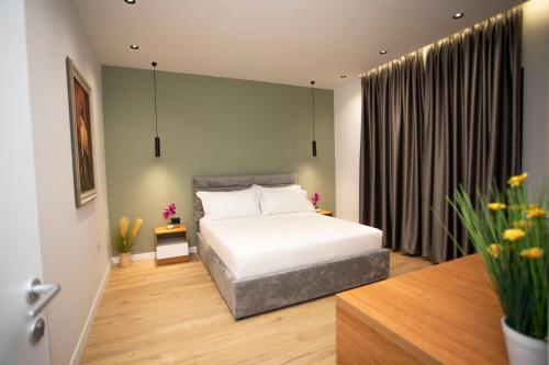 a bedroom with a white bed and a window at Villa Klaus Center Hotel in Tirana