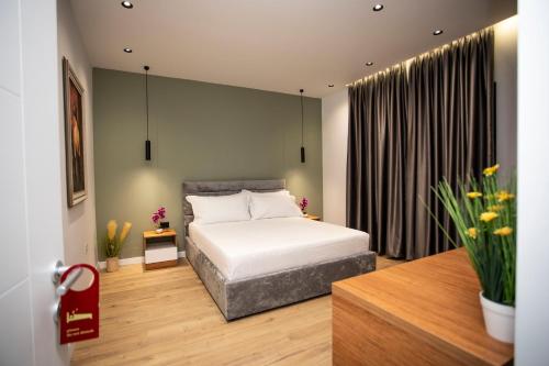 a bedroom with a bed and a large window at Villa Klaus Center Hotel in Tirana