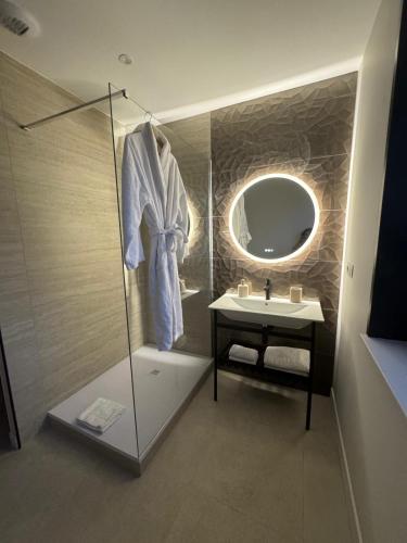 a bathroom with a shower and a sink and a mirror at Villa Pavone in Angoulême