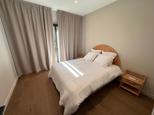 a bedroom with a bed with white sheets and a window at Villa Pavone in Angoulême