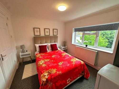a bedroom with a red bed and a window at New York Ensuite Double Room in London