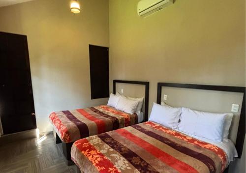 a hotel room with two beds in a room at Hotel Real Campestre Tepetoci in Tepexi del Río