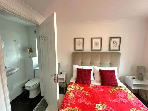 a bedroom with a bed and a bathroom with a toilet at New York Ensuite Double Room in London