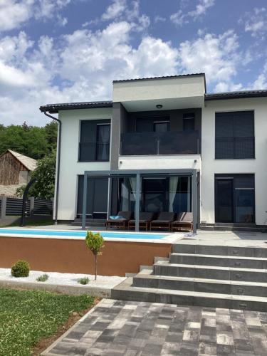 a large white house with a swimming pool at Villa Biser Gacke in Sinac