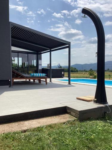 a pavilion with a bench next to a pool at Villa Biser Gacke in Sinac