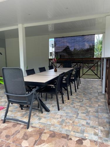 a dining table and chairs on a patio at Tiva Here Lodge Tahaa in Tahaa