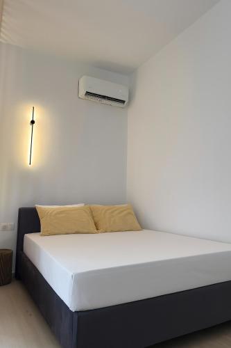 a bed in a room with a white wall at LaLaLa Cosy Studio in Koutsourás
