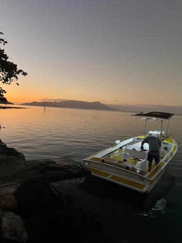 a man standing on a boat in the water at Tiva Here Lodge Tahaa in Tahaa