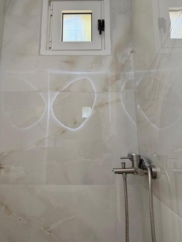 a bathroom with a shower and a window at LaLaLa Cosy Studio in Koutsourás