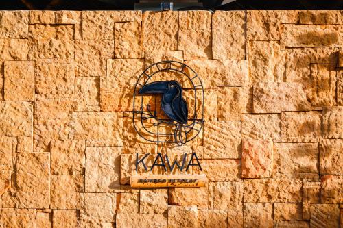 a black bird sitting on the side of a brick wall at Kawa Bamboo Retreat in Pereira