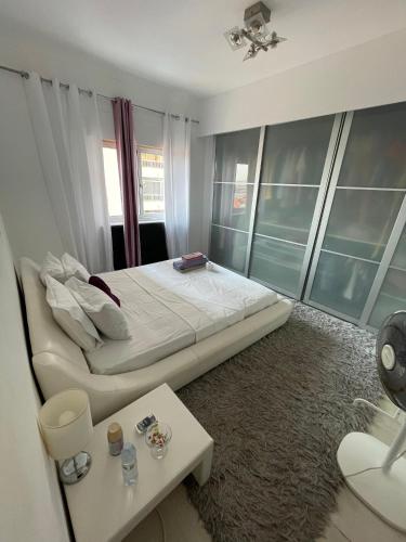 a bedroom with a large bed and a table at Quarto privado num apartamento partilhado in Bobadela