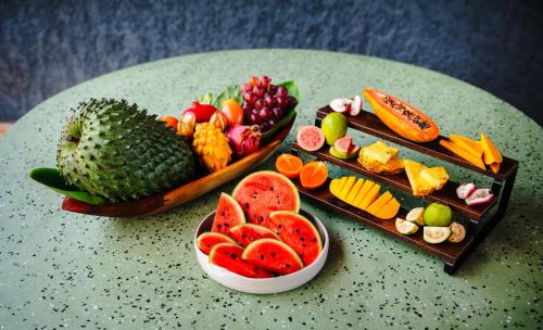 a table with two trays of different types of fruit at Kawa Bamboo Retreat in Pereira